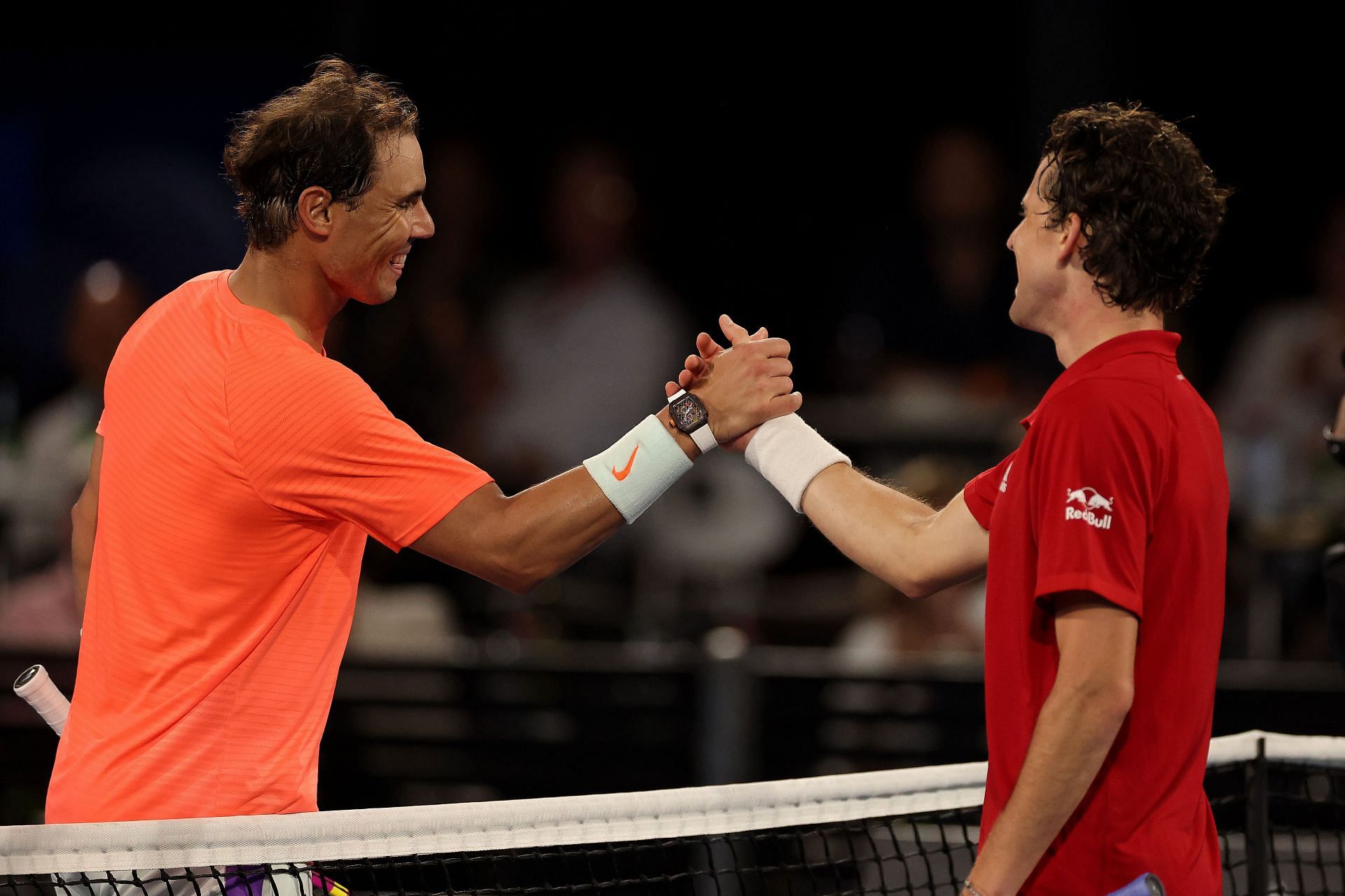 Rafael Nadal and Dominic Thiem embrace at the net following a match
